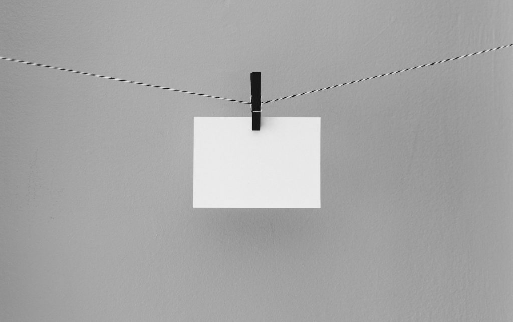 decorative image: paper hanging from clothes pin on string