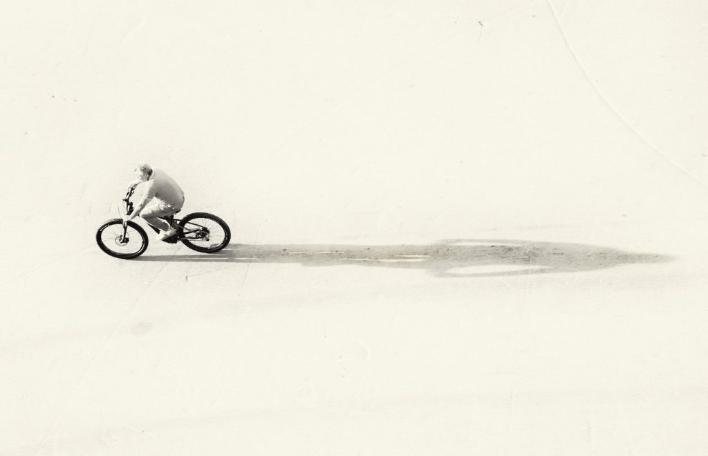 bike rider with shadow stretching behind