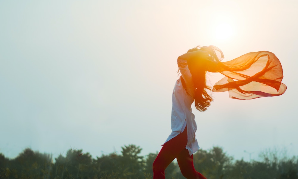 woman holding scarf fluttering in breeze