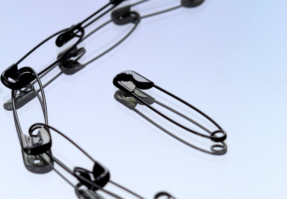 safety pins connected, except for one