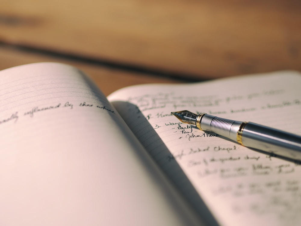 pen on top of notebook with notes in it